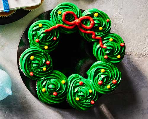 Green icing ringed pull-apart cake shaped and iced to resemble a cheery Christmas wreath.