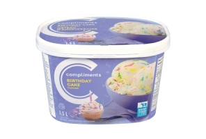  A purple tub of Compliments Birthday Cake Flavour Ice Cream with a photograph of a birthday cupcake with a candle in it on front.