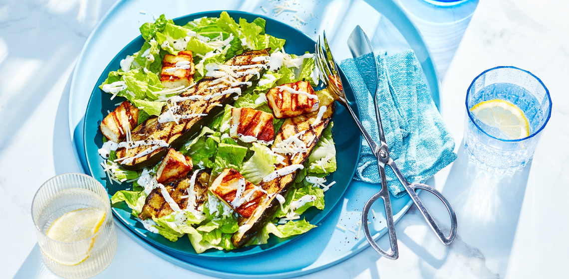 Large serving platter with grilled zucchini strips, romaine lettuce, halloumi croutons and caesar dressing