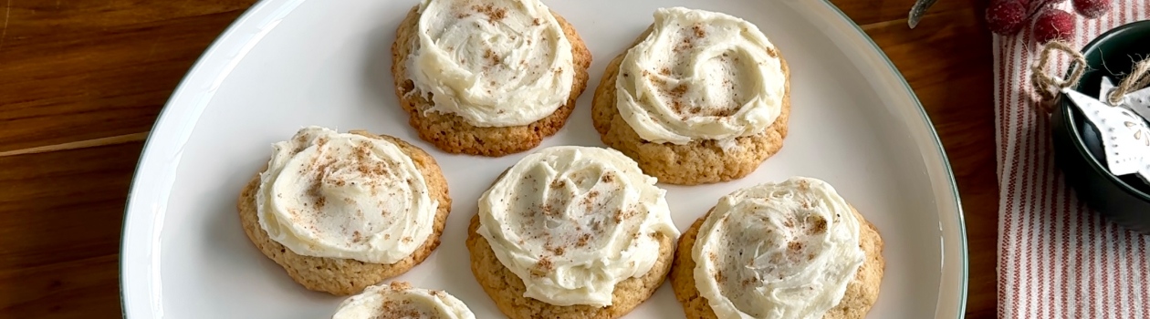 Frosted eggnog spiced cookies on a white plate