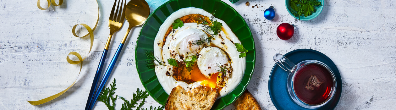 Overhead shot of Turkish eggs with bread on the side